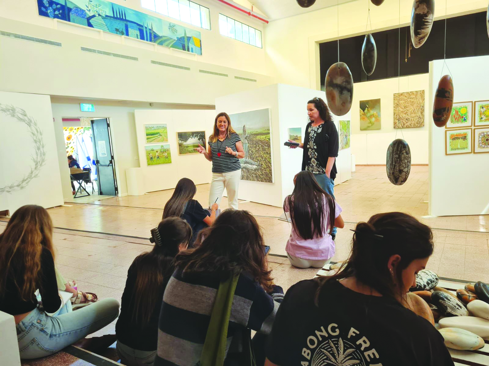 תלמידים מאזינים להרצאה על היצירות בתערוכה