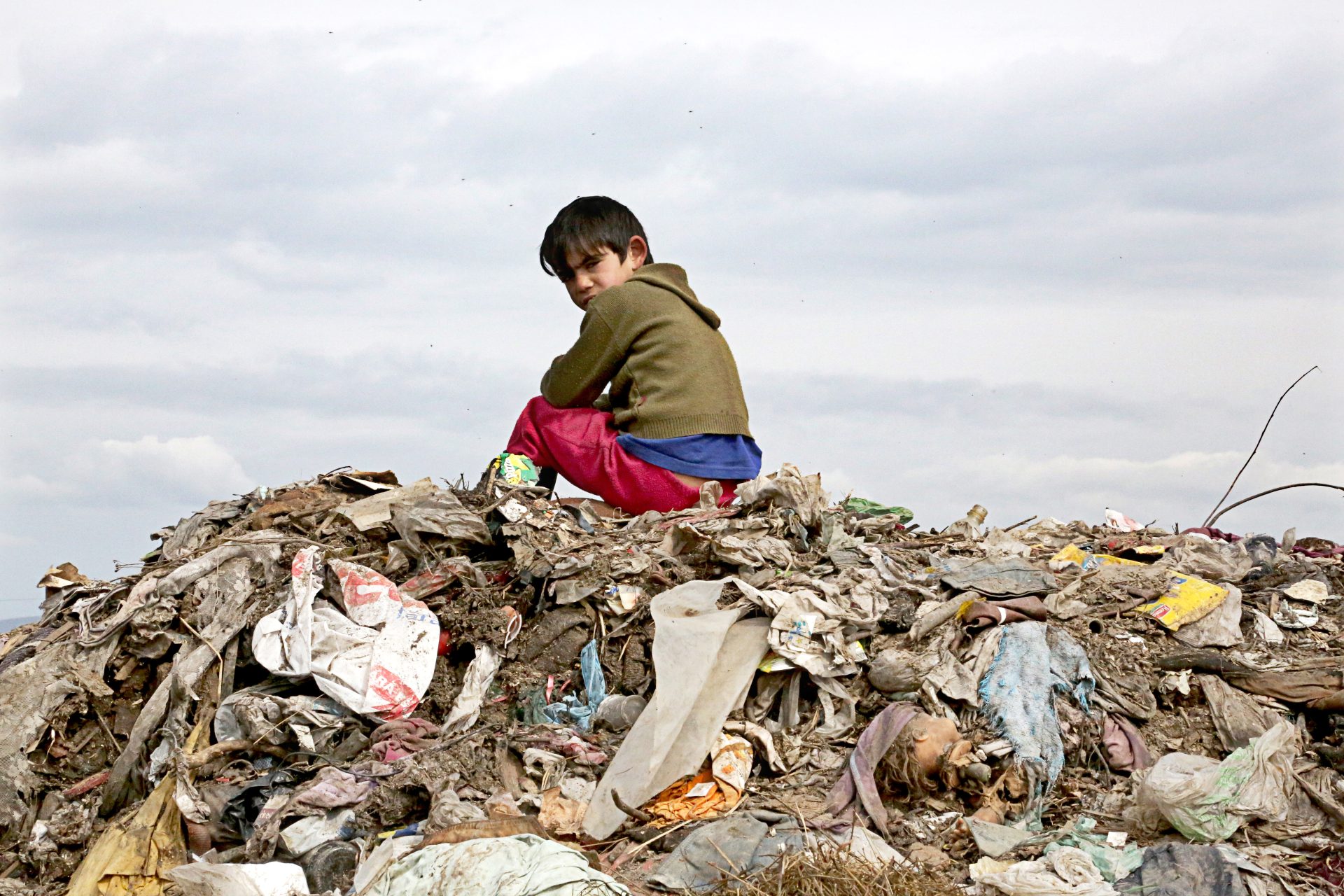 ילד צועני יושב על הר זבל, שהוא מקום המשחקים שלו. צילום רוני בן ארי.jpg