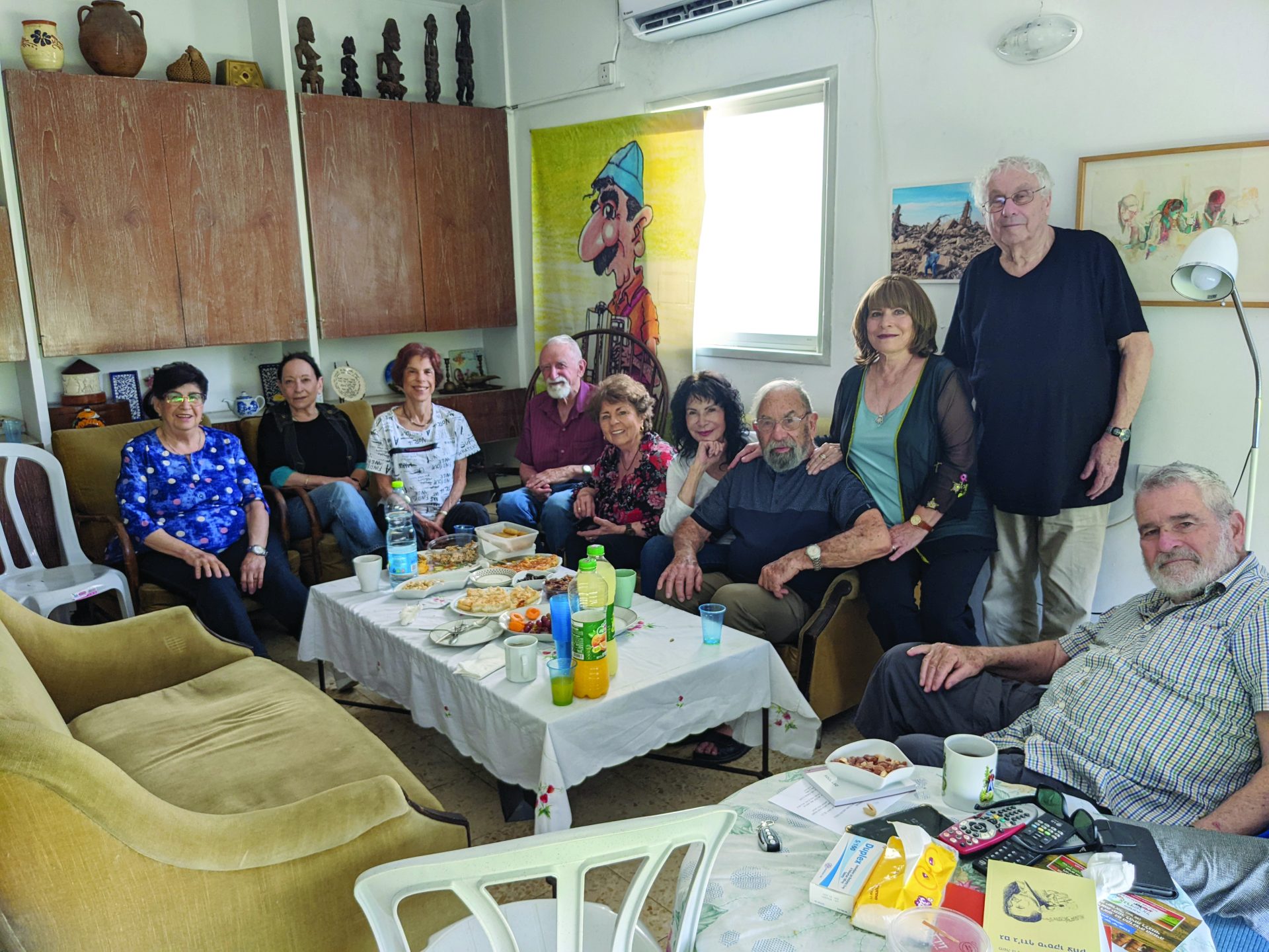 מפגש סופרי ילדים אצל פוצ'ו בבית. מימין יהודה אטלס (יושב) , אהוד הן עזר, עדינה בר אל, פוצ'ו ואחרים (2022)